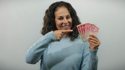Middle-aged woman holding israeli shekel banknotes gives a thumbs-up sign against a white...