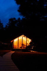 Glamping from tent houses in the forest in the dark.