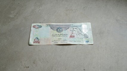 Banknote of united arab emirates dirham on concrete surface featuring intricate designs and an...