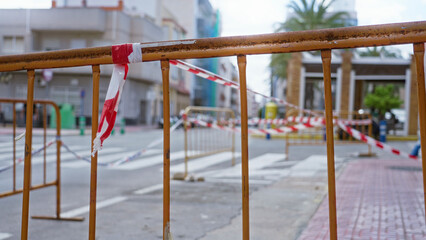 Street with barricades and caution tape in a sunny urban area showing a closed section for...