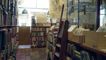 Defocused view of a library with shelves full of books and wooden crates under soft light, creating an inviting and scholarly atmosphere.