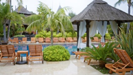 Blurred view of a luxury tropical resort showcasing defocused palm trees and bokeh effect around an...