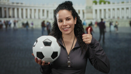 Woman with soccer ball in st. peter's square, vatican city, giving a thumbs up, embodies energy and...