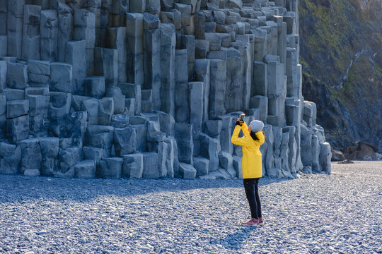Exploring the majestic basalt columns at Reynisfjara Beach in Iceland during a sunny day - Powered by Adobe