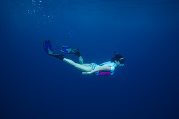Woman freediving with snorkel in Maldives. Freediving athlete. Woman freediving in blue medium water.