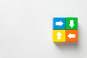 Colorful wooden blocks with arrows pointing in different directions (up, down, left, right) on...