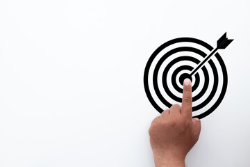 A person's finger pointing to the bullseye of a target icon. Concept for business goal setting,...
