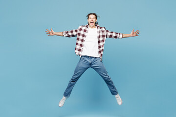 Full body young shocked surprised man he wears purple checkered shirt casual clothes jump high look...