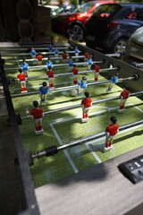 Exciting tabletop foosball game in action. Players compete by spinning rods to control miniature...