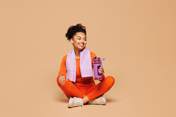 Full body young fitness trainer instructor woman sportsman she wear orange clothes towel spend time...