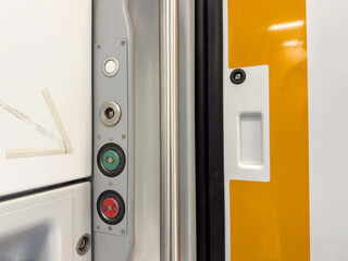 Close-up of train door panel with buttons and latch