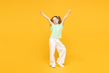 Full body little kid child girl 8-9 years old wear green t-shirt do winner gesture celebrate clench...
