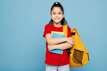 Young smart happy school girl 8-9 years old pony tail wears red t-shirt backpack hold books look...