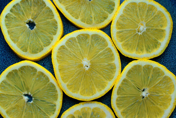 Ripe lemon slices on blue ceramic background. Fruit salad.