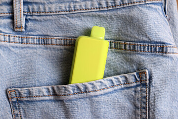 One multi-colored electronic cigarette in the pocket of jeans. Vape with nicotine.