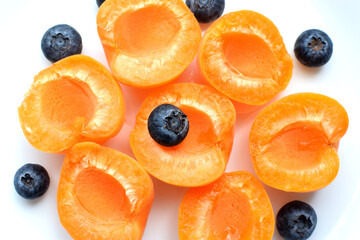 Ripe tasty slices of apricot with blueberries. Fruit salad.