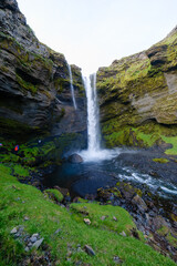 Majestic Kvernufoss waterfall cascading down rocky cliffs in Icelands lush landscape