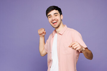 Young man he wears pink shirt t-shirt casual clothes doing winner gesture celebrate clenching fists...