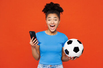 Young surprised woman fan wearing basic blue t-shirt cheer up support football sport team hold in...