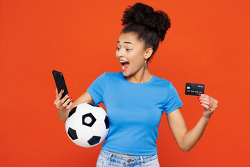 Young woman fan in basic blue t-shirt cheer up support football sport team hold soccer ball credit...