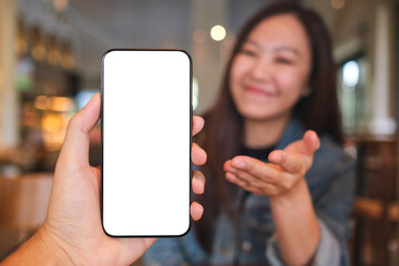 Mockup image of a man holding and a woman open hand to a mobile phone with blank screen
