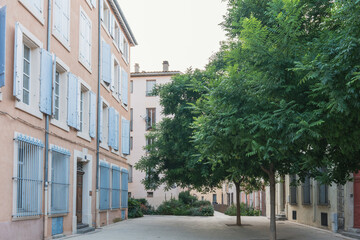 Quiet Courtyard with Blue Shutters and Trees in Narbonne, France
