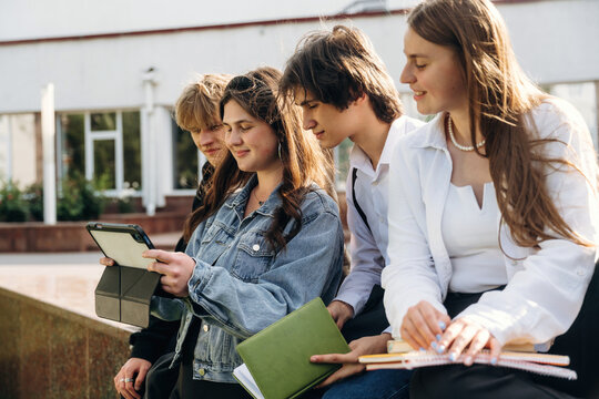 Using digital tablet. Group of students are near university together - Powered by Adobe