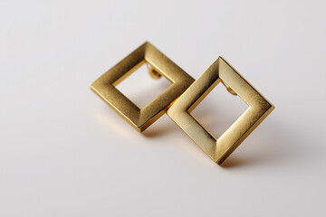 Geometric gold square earrings on white background