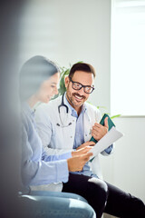 Doctor Discussing Patient Health Report with Woman in Bright Office Setting
