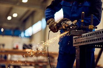 Worker Grinding Steel with Sparks in an Industrial Workshop Setting
