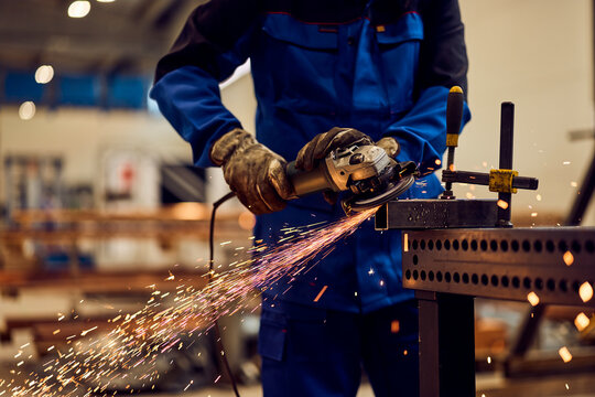 Worker Grinding Metal with Sparks in an Industrial Workshop Setting