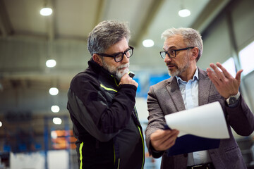Businessmen Collaborating and Discussing Project in an Industrial Workplace Setting