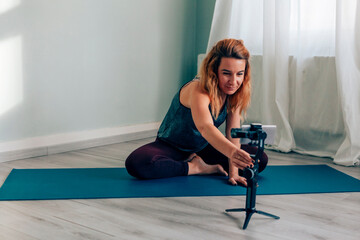 Yoga teacher recording online class with smartphone gimbal at home