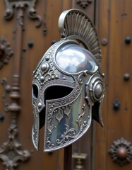 Silver Ornate Ancient Greek Helmet Displayed Against Wooden Door