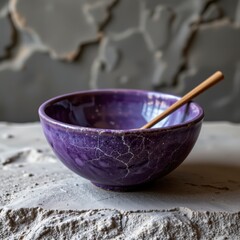 Purple Ceramic Bowl with Wooden Spoon on Gray Stone Surface