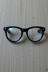 Black Round Eyeglasses on Light Brown Wooden Surface