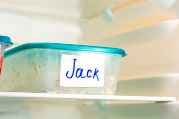 Plastic food containers with name stickers in spacious office fridge. Well organized office kitchen for employers.