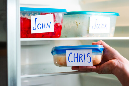 Man taking his lunch box from office fridge during lunch time.