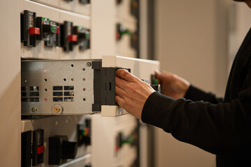Person Handling Electrical Equipment in a Professional Setting for Maintenance or Installation