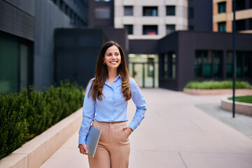 Confident Businesswoman Walking Outside Modern Office Building In Stylish Attire