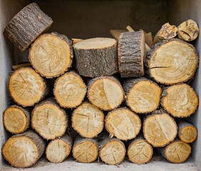 Sawn round firewood. Pile of stacked wood logs.