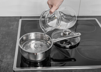 Pour water from the jug into the pot, boiled water