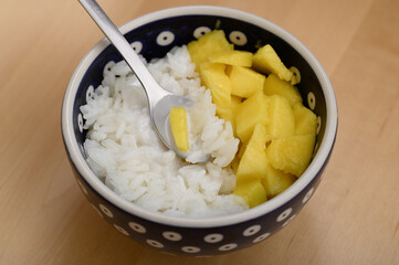 A bowl with a portion of dietetic, easily digestible rice with mango, Asian cuisine