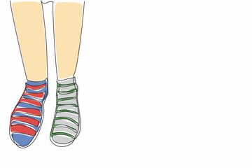 Single one line drawing different stripes between right and left. Comfort comes first, differences are a matter of taste. Colorful socks. Anti Bullying Day. Continuous line design graphic illustration