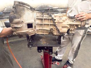 A team of expert technicians is performing maintenance on a complex car transmission system. 
