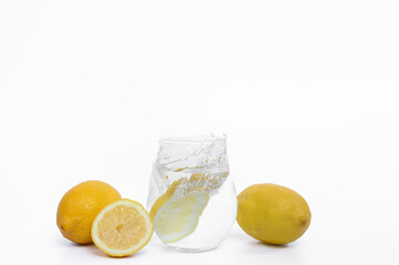 Glass of water with lemon on white background, drink