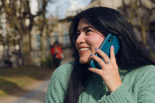 very happy young woman in love talking on the phone outdoors