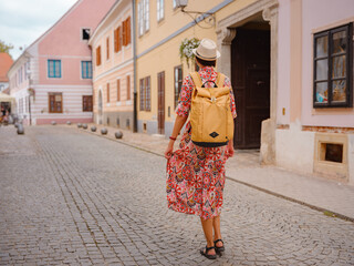 Beautiful woman walking of Varazdin streets during summer day in old, historical city center. Tourist exploring the beautiful streets, experiencing relaxed and cultural vibe of this Croatian city.