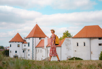 Beautiful woman walking of Varazdin streets during summer day in old, historical city center. Panorama and Cityscape of famous Croatian fortress town in Europe in summer. Travel and tourism