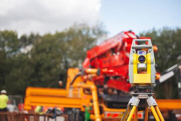 Land surveyors equipment theodolite or total positioning station set on tripod at construction site...